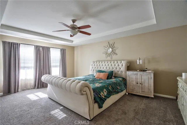 a spacious bedroom with a bed and a chandelier