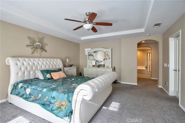 a living room with a bed furniture chandelier and a rug