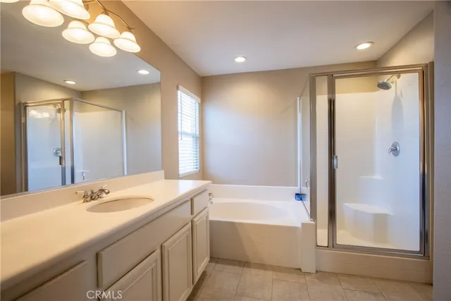 a bathroom with a bathtub shower sink vanity and mirror