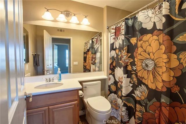 a bathroom with a toilet a sink and a shower curtain