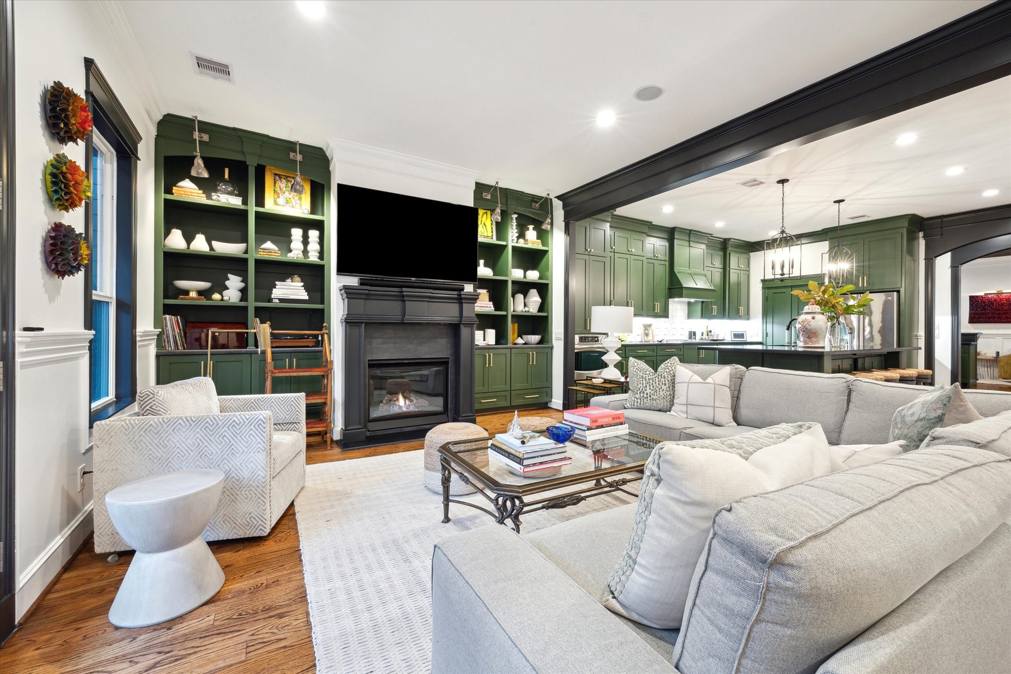 606 Rutland Street Houston, TX 77007 - Photo 24 of 48 The open-concept living space features a a modern fireplace, and elegant built-in shelving. The kitchen boasts a spacious island, and contemporary lighting, creating a perfect blend of comfort and sophistication.