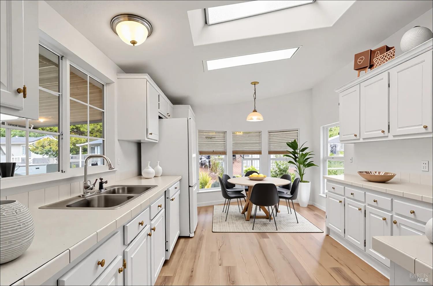 a kitchen with white cabinets and sink
