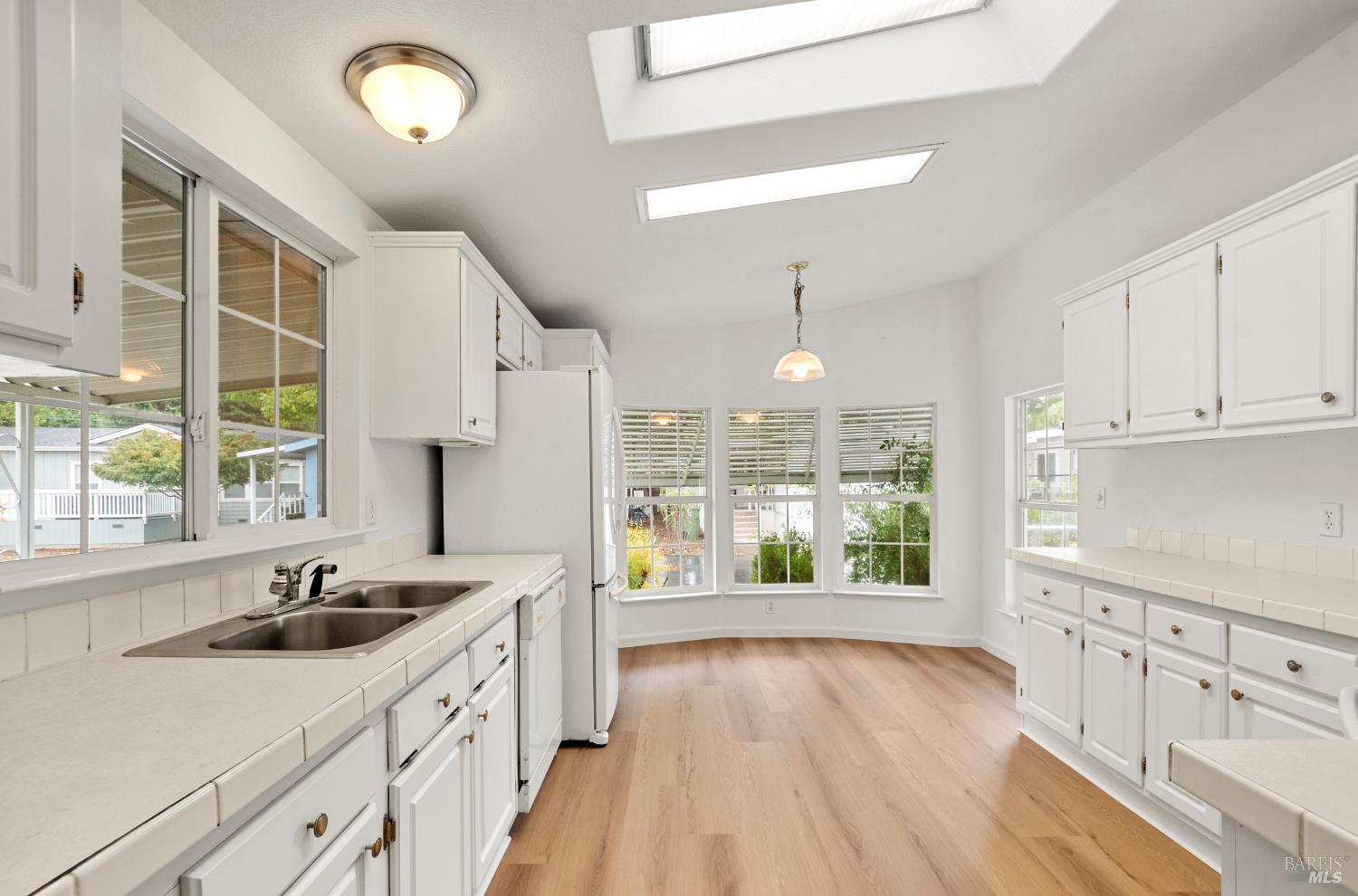 2412 Foothill Boulevard, Unit 41 Calistoga, CA 94515 - Photo 11 of 33 a large kitchen with granite countertop a large window a sink stainless steel appliances and cabinets