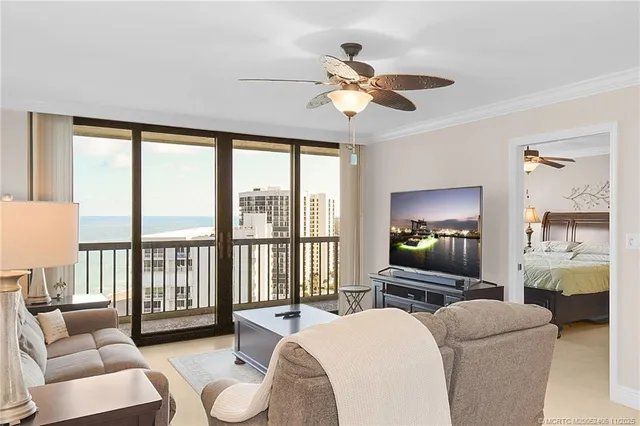 a living room with furniture large windows and a flat screen tv