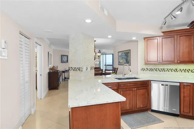 a kitchen with a sink a counter top space and living room view