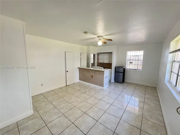 a large white kitchen with white cabinets and chandelier