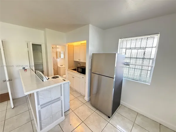 a kitchen with a refrigerator a stove top oven and a window