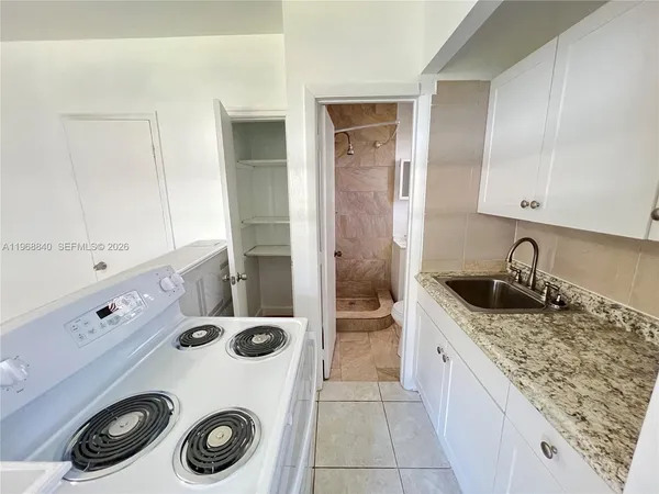 a kitchen with a sink a stove and cabinets