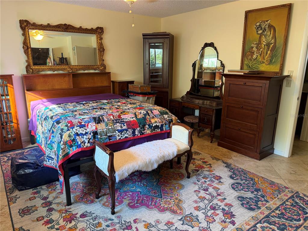 9529 Southwest 85th Avenue, Unit D Ocala, FL 34481 - Photo 11 of 21 a bedroom with a bed a dresser and mirror