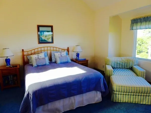 a bedroom with a bed wooden floor and window