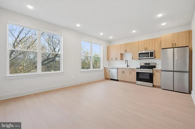 a kitchen with stainless steel appliances a refrigerator and a stove top oven