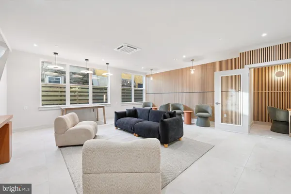 a living room with furniture a large window and flat screen tv