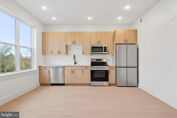 a kitchen with a refrigerator and a stove top oven