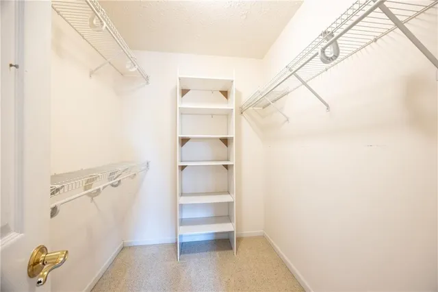 a view of walk in closet with empty racks