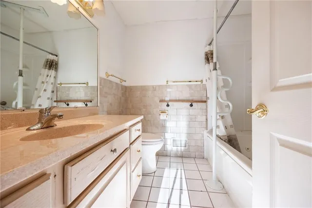 a bathroom with a granite countertop sink a toilet and shower