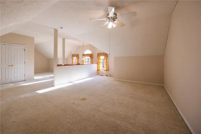 en empty room with windows and ceiling fan