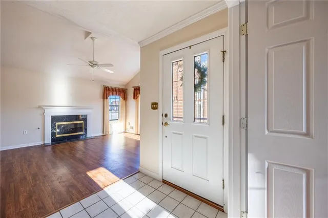 an empty room with wooden floor fireplace and windows