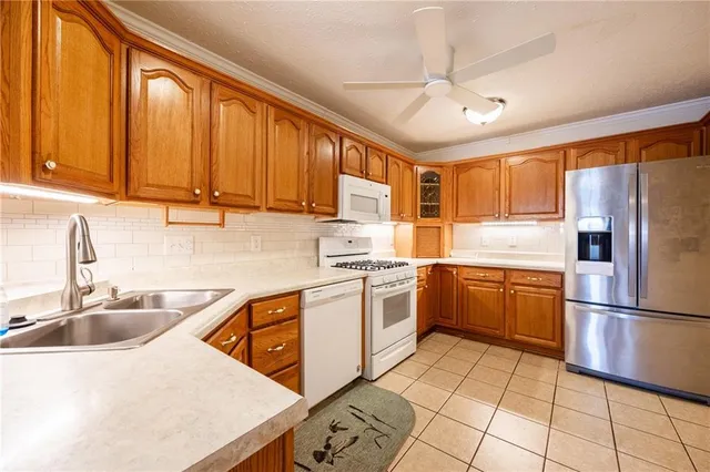a kitchen with a sink refrigerator and cabinets