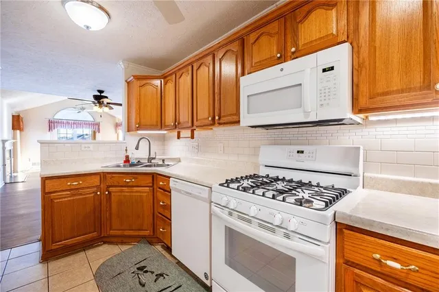 a kitchen with stainless steel appliances granite countertop a sink stove and cabinets