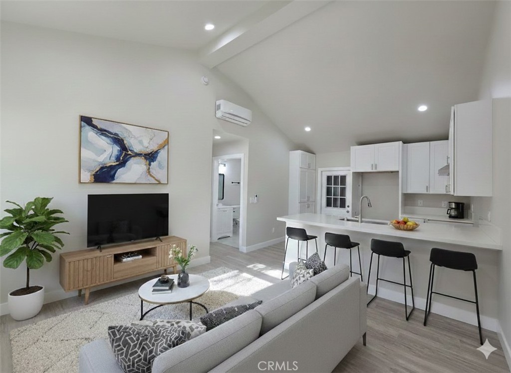 a living room with furniture kitchen view and a potted plant