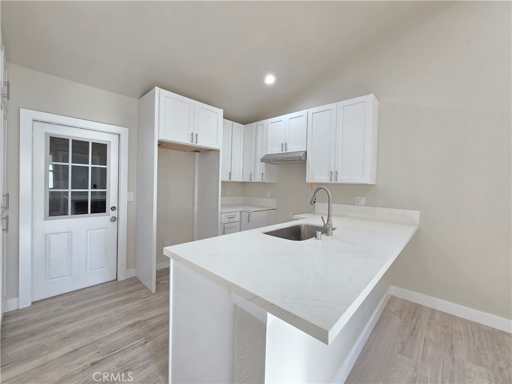 3871 Bandini Avenue Riverside, CA 92506 - Photo 6 of 11 a kitchen with a sink refrigerator and cabinets