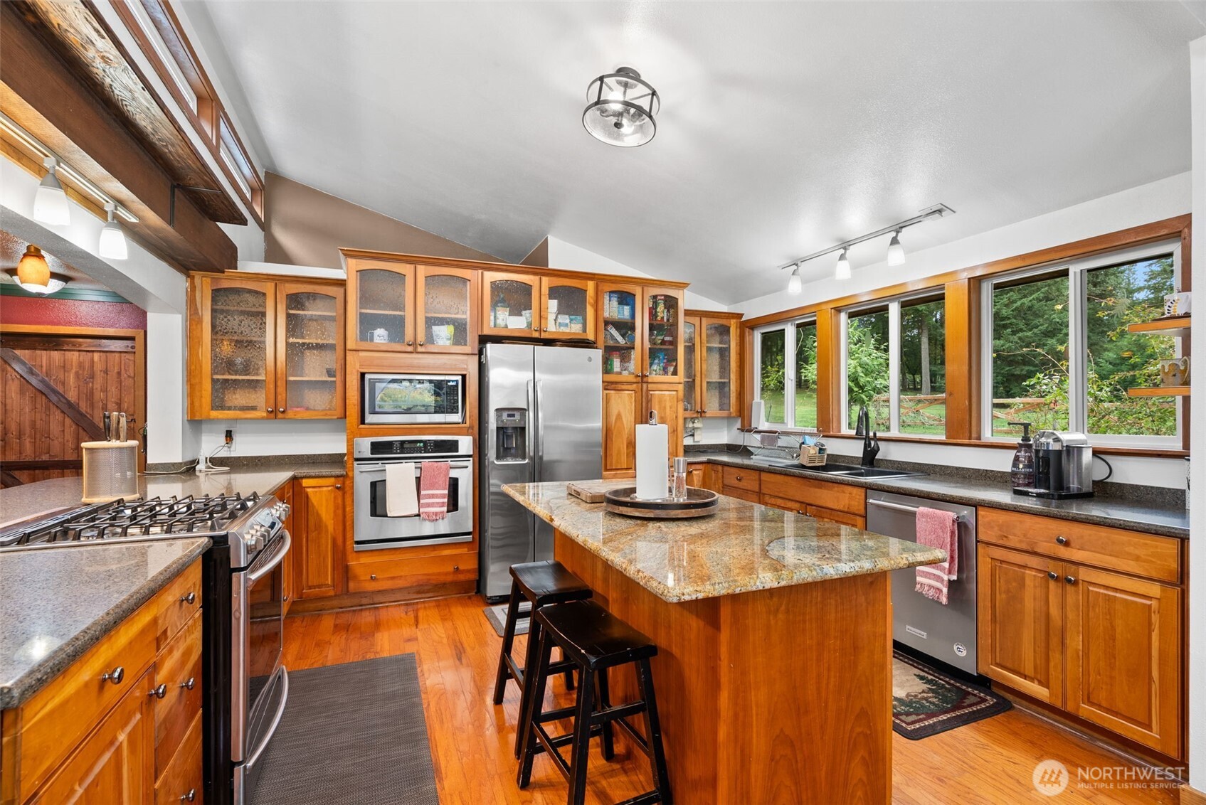 4914 182nd Avenue Southwest Longbranch, WA 98351 - Photo 22 of 37 a kitchen with stainless steel appliances granite countertop sink stove and wooden cabinets