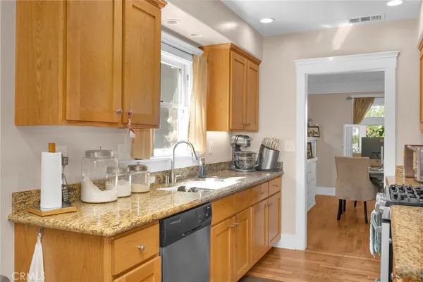 a kitchen with stainless steel appliances granite countertop sink stove refrigerator and cabinets