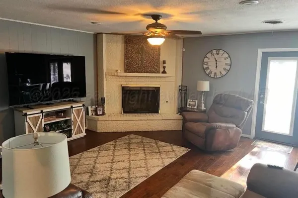 a living room with furniture a fireplace and a flat screen tv