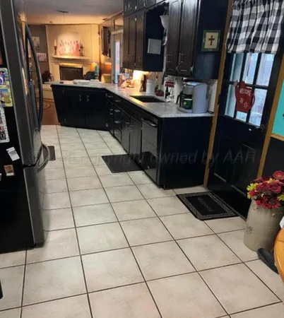a kitchen with granite countertop a sink and a stove top open