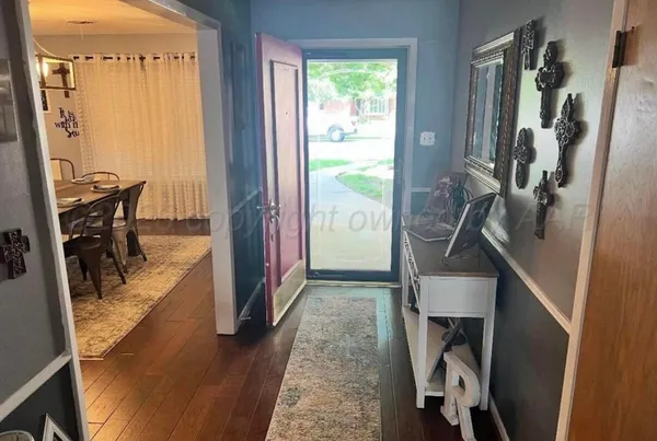 a view of a hallway with furniture and a window