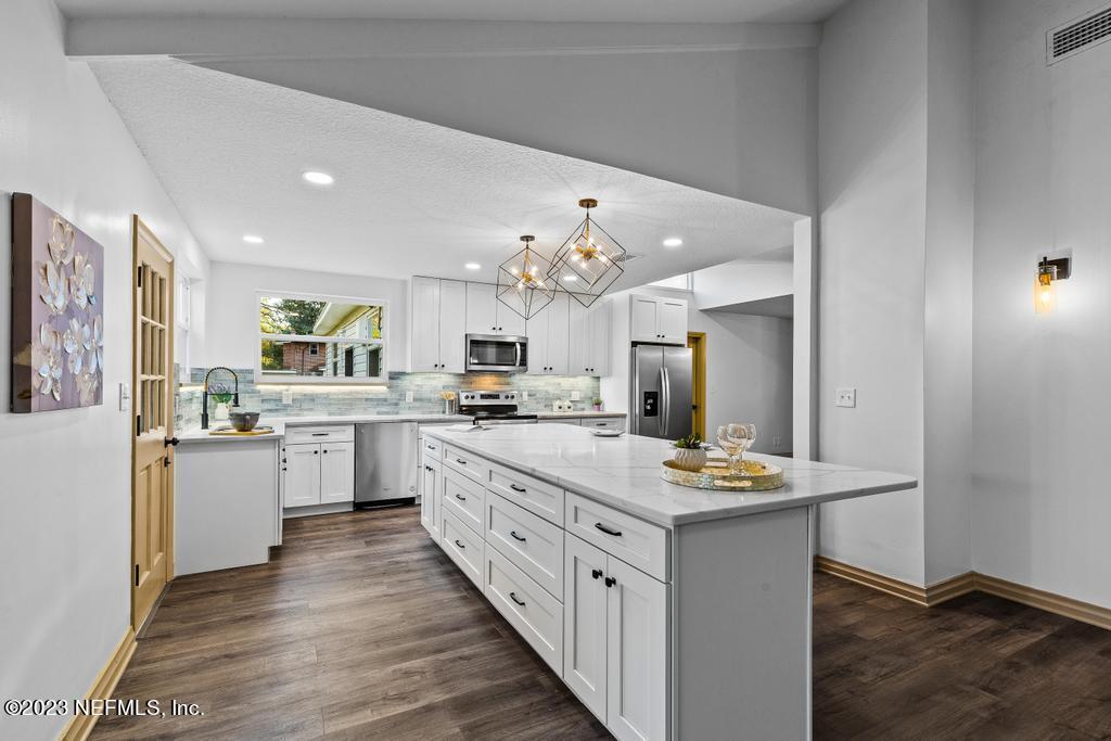 17 River Road Orange Park, FL 32073 - Photo 17 of 49 a kitchen with kitchen island granite countertop lots of white stainless steel appliances cabinets and a center island
