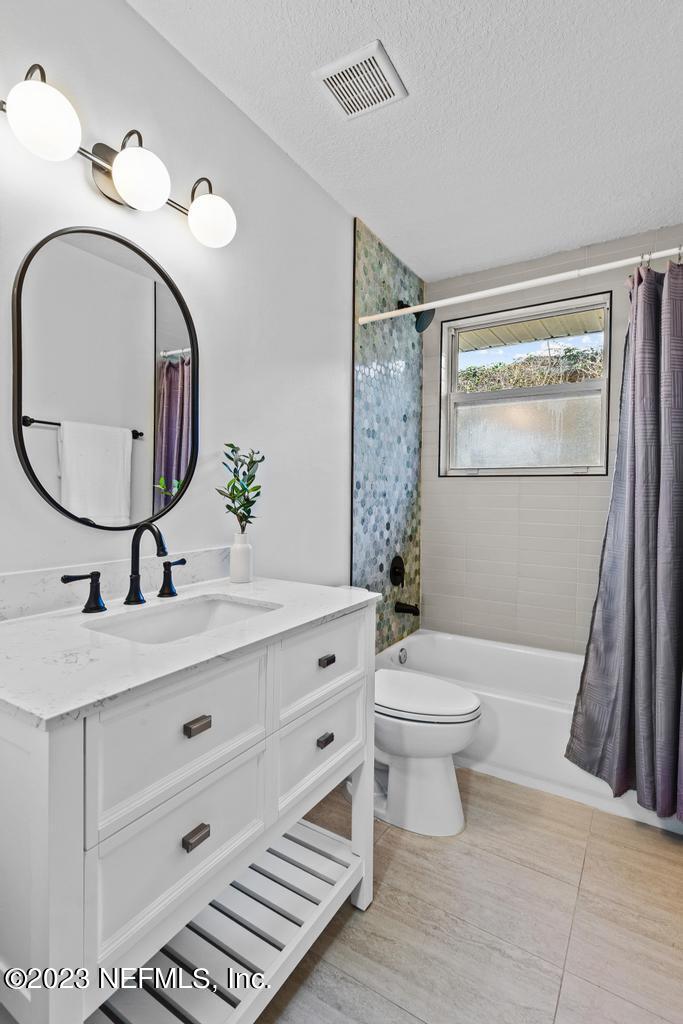 17 River Road Orange Park, FL 32073 - Photo 25 of 49 a bathroom with a sink a mirror a toilet and a window