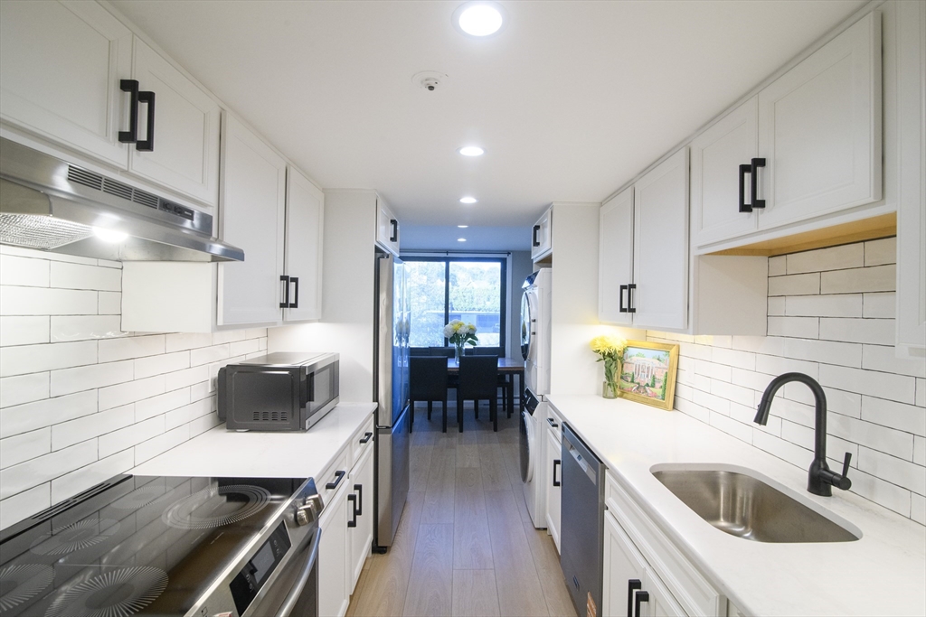 a kitchen with kitchen island a stove and a sink
