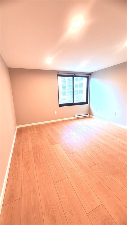 49 Melrose Street, Unit 1H Melrose, MA 02176 - Photo 11 of 20 a view of an empty room with window and wooden floor