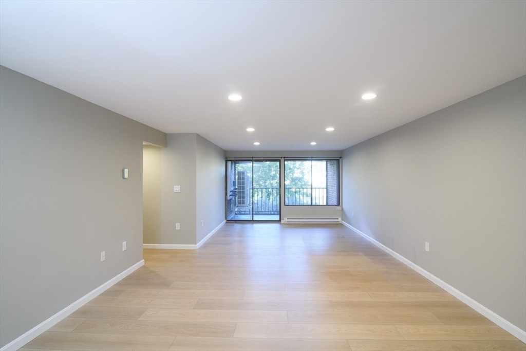 49 Melrose Street, Unit 1H Melrose, MA 02176 - Photo 5 of 20 an empty room with wooden floor and windows