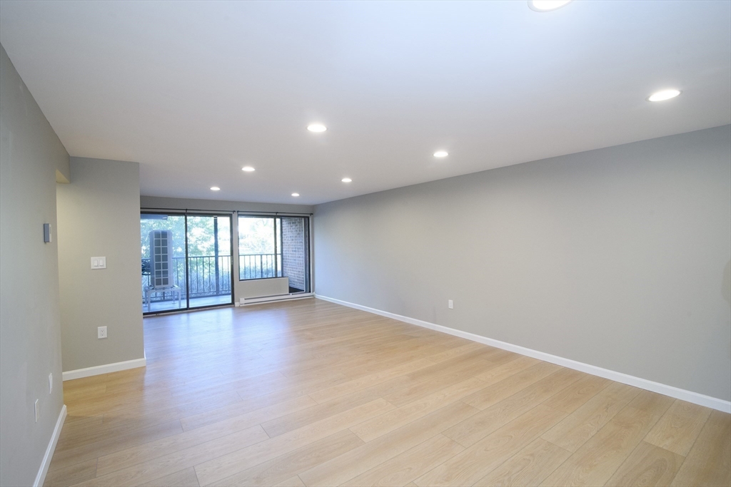 49 Melrose Street, Unit 1H Melrose, MA 02176 - Photo 6 of 20 an empty room with wooden floor and windows