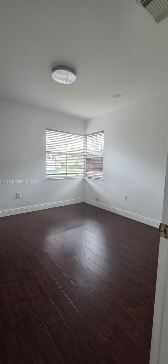 11787 Southwest 90th Terrace, Unit 11787 Miami, FL 33186 - Photo 7 of 17 an empty room with wooden floor and windows