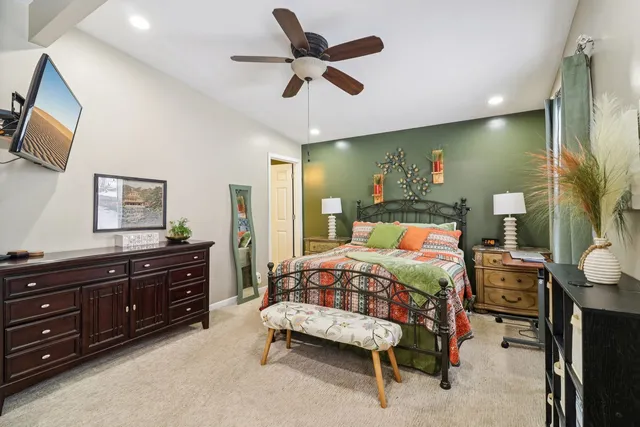 a bedroom with a bed and a mirror on the dresser