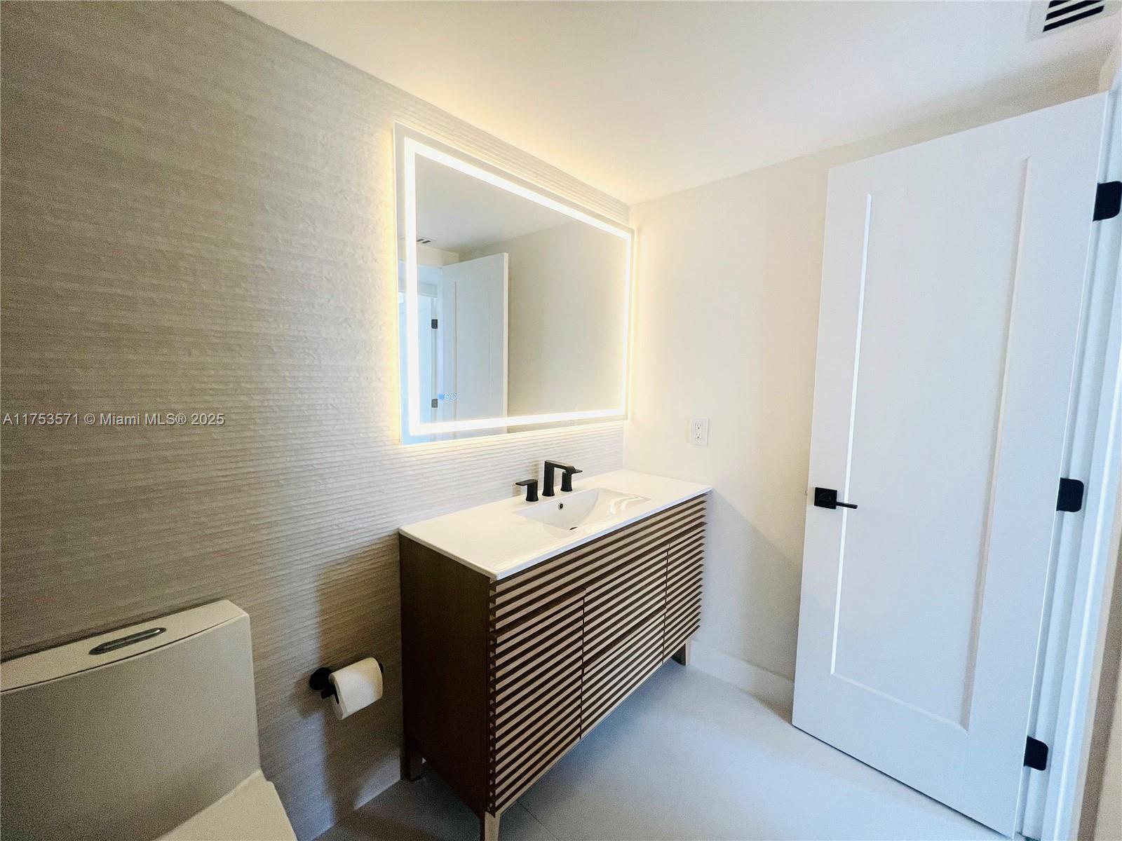 201 Jefferson Avenue, Unit 4C Miami Beach, FL 33139 - Photo 15 of 35 a bathroom with a sink a toilet and a mirror