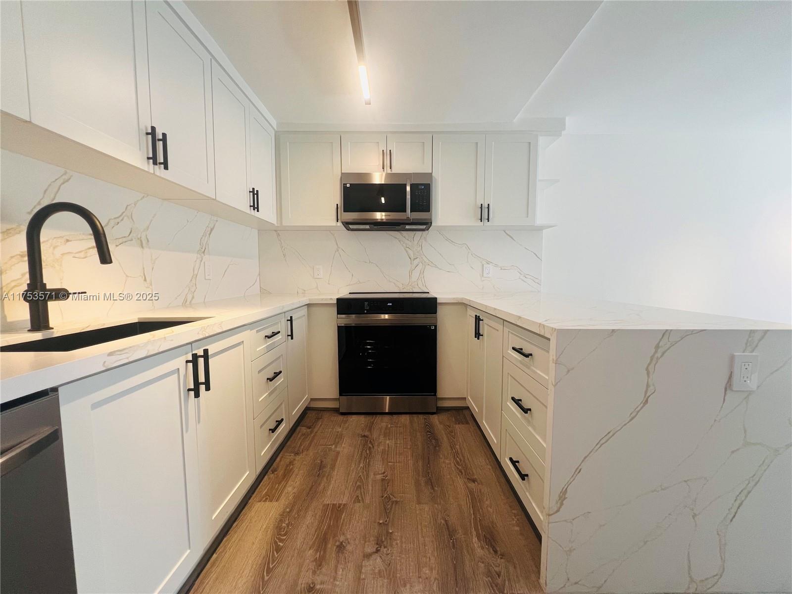 201 Jefferson Avenue, Unit 4C Miami Beach, FL 33139 - Photo 17 of 35 a kitchen with granite countertop a sink stove and refrigerator