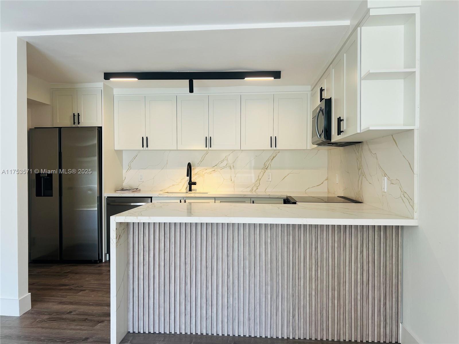 201 Jefferson Avenue, Unit 4C Miami Beach, FL 33139 - Photo 19 of 35 a kitchen with a refrigerator sink and cabinets