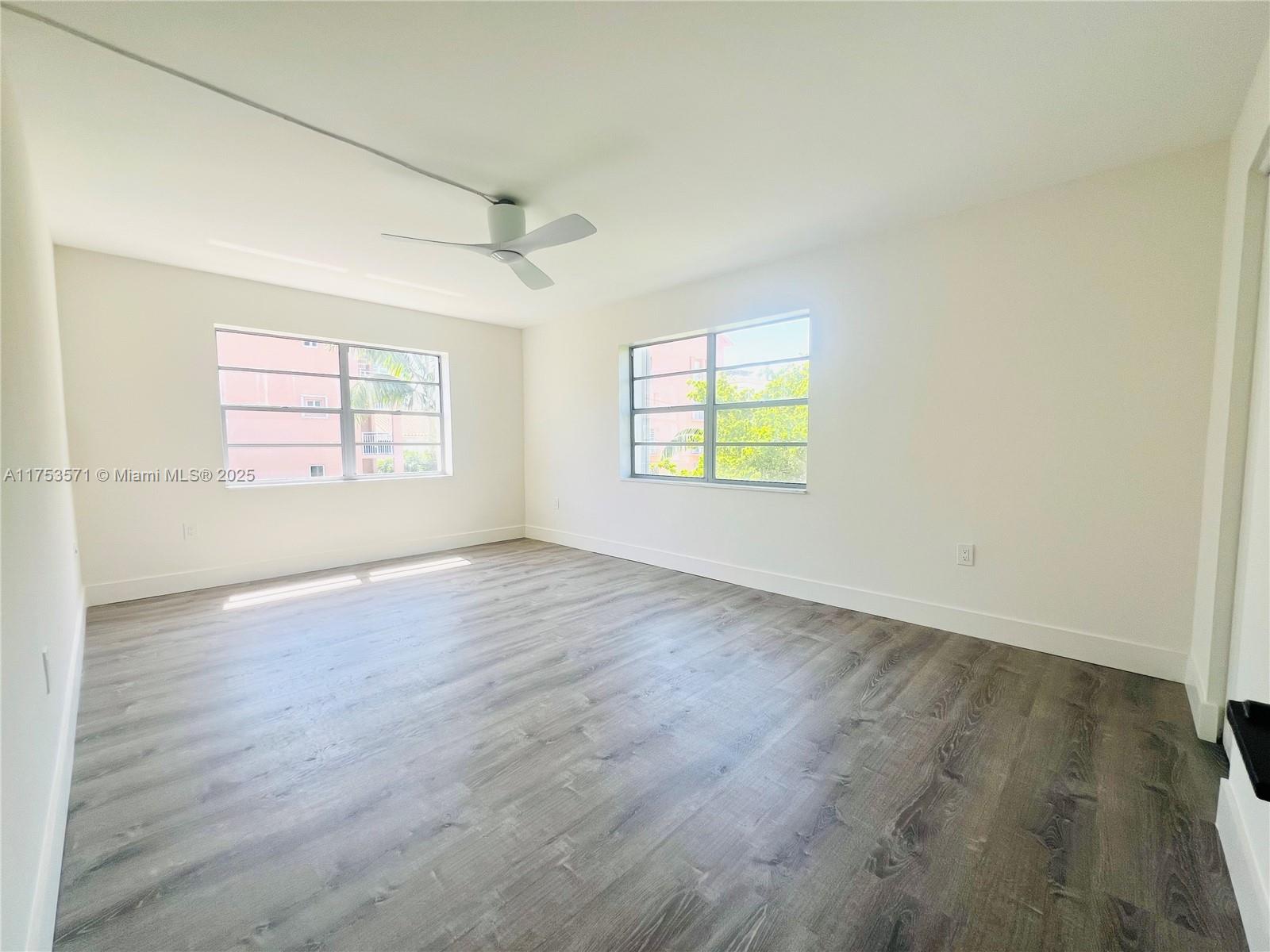 201 Jefferson Avenue, Unit 4C Miami Beach, FL 33139 - Photo 26 of 35 an empty room with wooden floor and windows