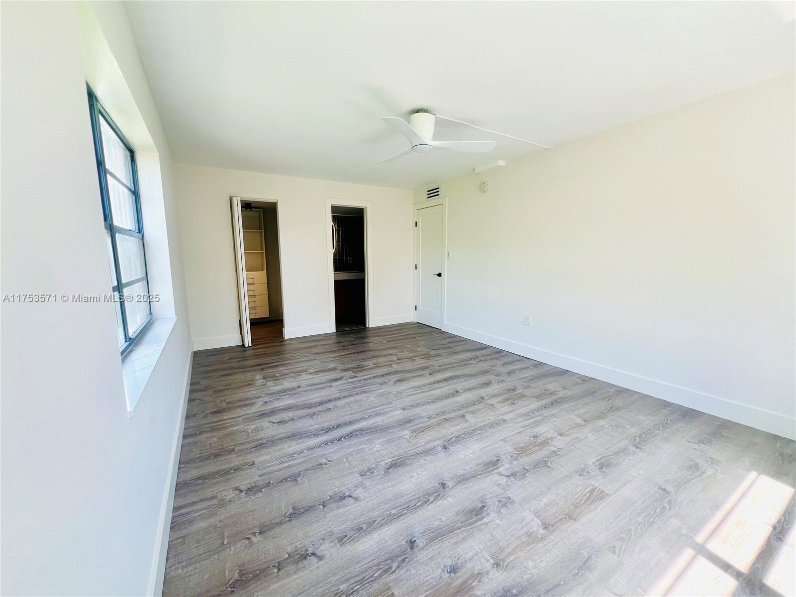 201 Jefferson Avenue, Unit 4C Miami Beach, FL 33139 - Photo 27 of 35 an empty room with wooden floor and windows