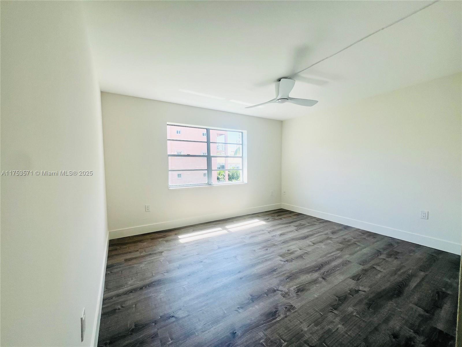 201 Jefferson Avenue, Unit 4C Miami Beach, FL 33139 - Photo 31 of 35 an empty room with wooden floor ceiling fan and windows