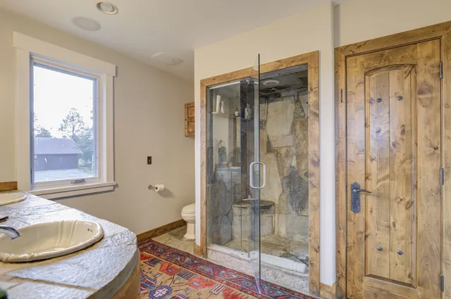 a bedroom with a bed a book shelf and a window