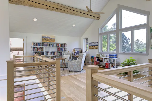 a bedroom with a bed a couch and large window