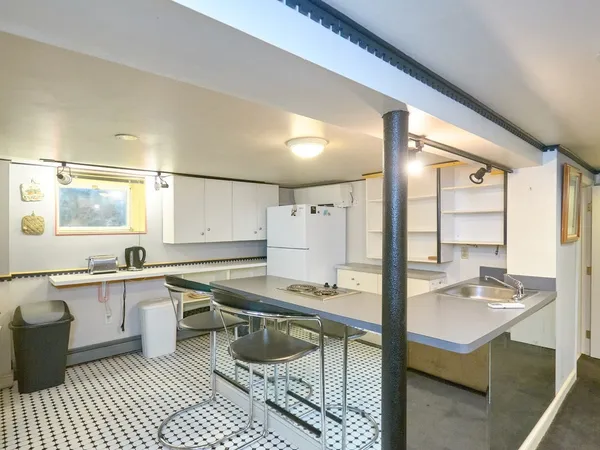 a kitchen with a sink and chairs