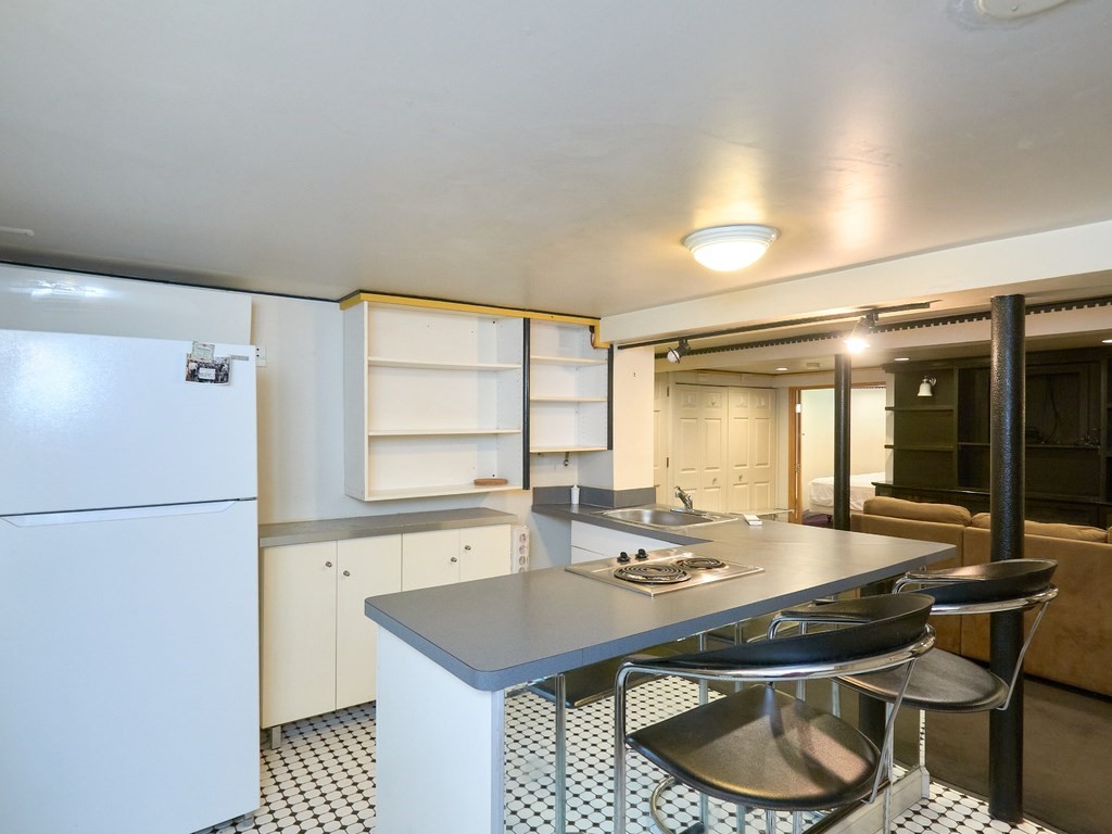 18 Atherton Road, Unit G Brookline, MA 02446 - Photo 10 of 15 a kitchen with granite countertop a sink and a refrigerator