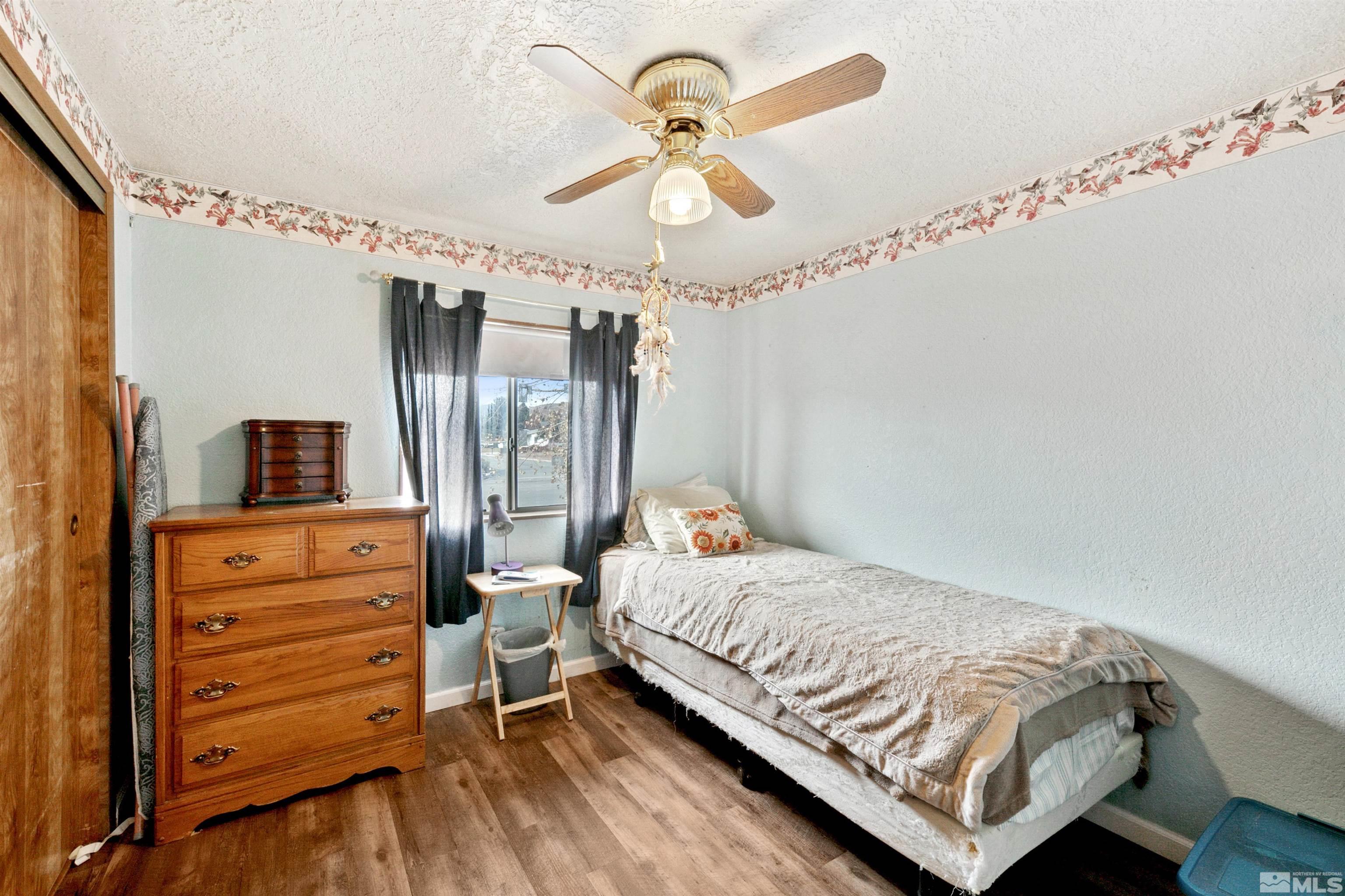 17405 Sunbird Lane Reno, NV 89508 - Photo 16 of 18 a bedroom with a bed and a chandelier