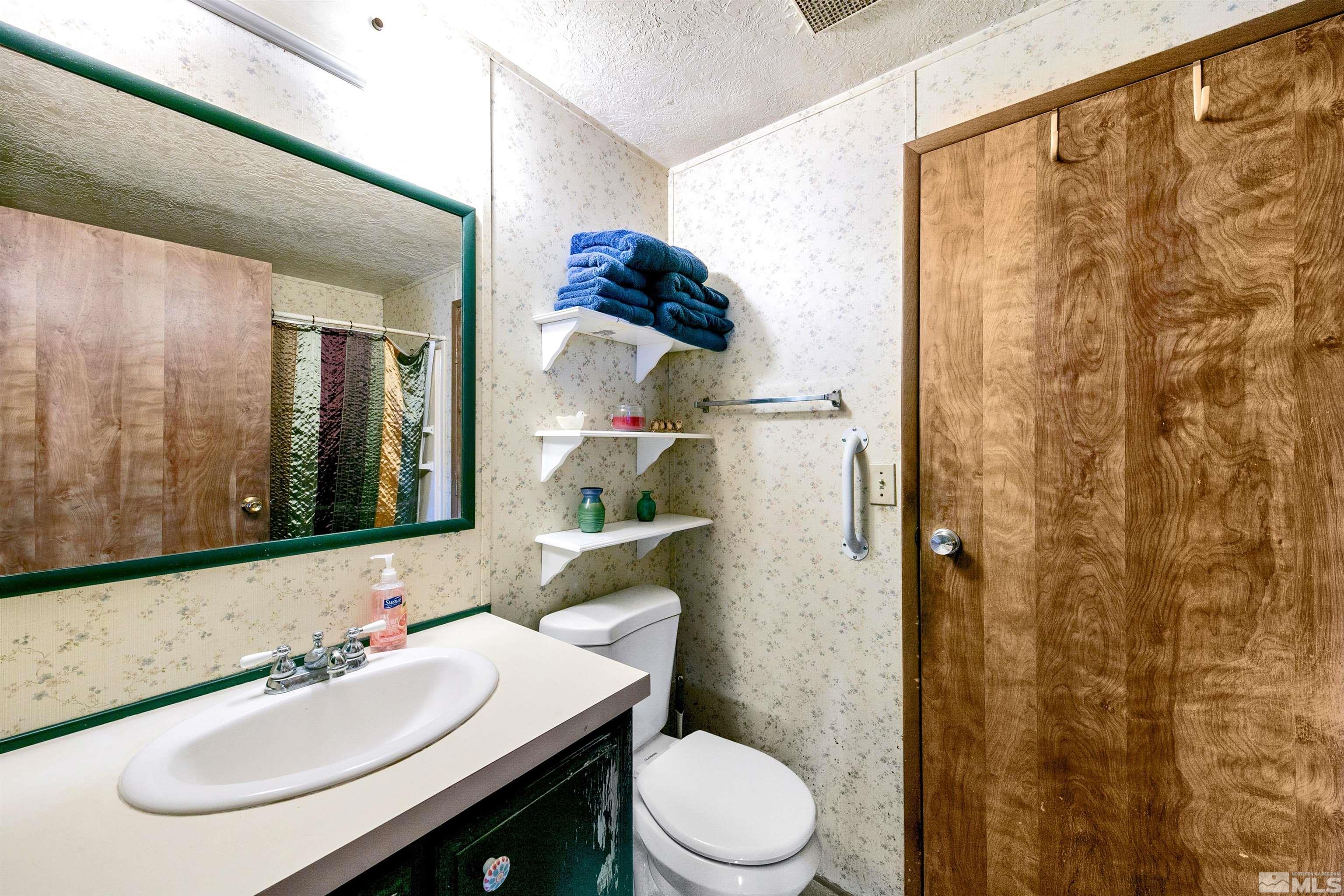 17405 Sunbird Lane Reno, NV 89508 - Photo 17 of 18 a bathroom with a sink vanity mirror and toilet